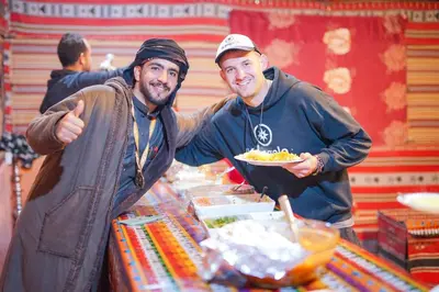 two men holding a plate of food at a buffet at Magic Bedouin Star in Wadi Rum