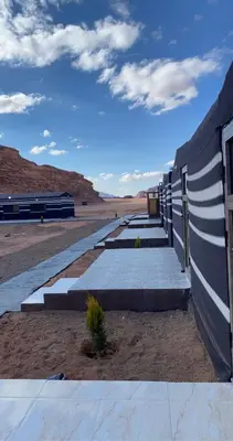 a row of concrete walkways next to a wall at Wadi Rum Sand Camp in Disah