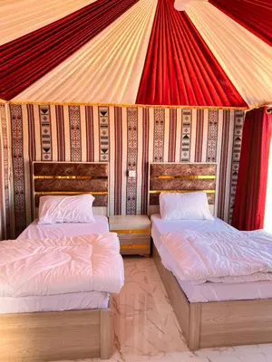 two beds in a room with a tent at Wadi Rum Sand Camp in Disah