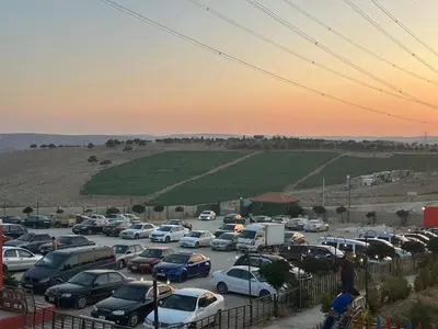a parking lot filled with lots of cars at sunset at Wadi Al-Wala View Camp in Madaba