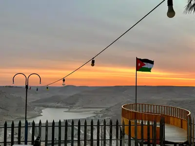 a flag on a pole with a view of a lake at Wadi Al-Wala View Camp in Madaba