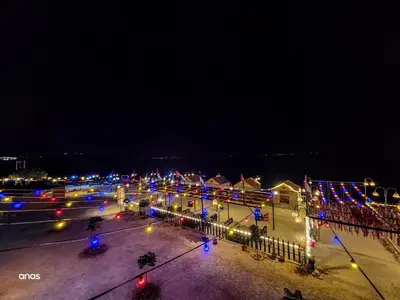 a parking lot with christmas lights at night at Wadi Al-Wala View Camp in Madaba
