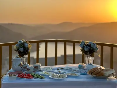 a table with a blue table cloth with food on it at Wadi Al-Wala View Camp in Madaba