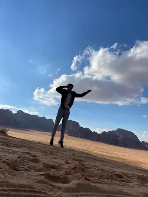 a man is standing in the middle of the desert at Enjoy Wadi Rum stars in Disah
