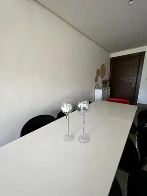 two wine glasses sitting on a white table at The bridge Residence in Amman