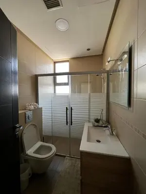 a bathroom with a toilet and a sink and a shower at The bridge Residence in Amman