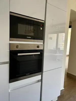 a microwave oven sitting in a white kitchen at The bridge Residence in Amman