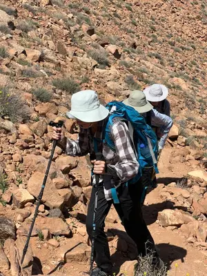 two men are walking on a rocky trail at Jori Luxury Camp in Wadi Rum