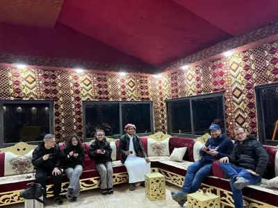 a group of people sitting on couches in a room at Desert Nights Camp in Wadi Rum