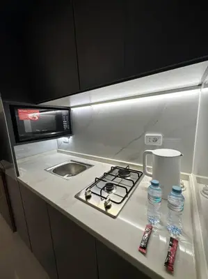 a small kitchen with a stove and a sink at modern apartment in abdoun-amman in Amman