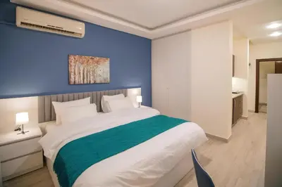 a bedroom with a large bed with a blue wall at 46 Serviced Apartments in Amman