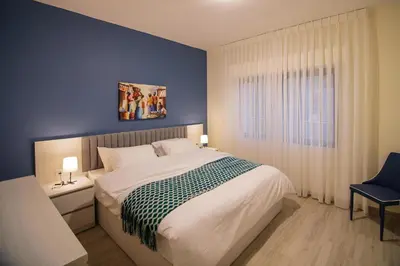 a bedroom with a large bed and a blue wall at 46 Serviced Apartments in Amman