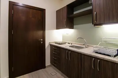 a kitchen with a sink and a wooden door at 46 Serviced Apartments in Amman