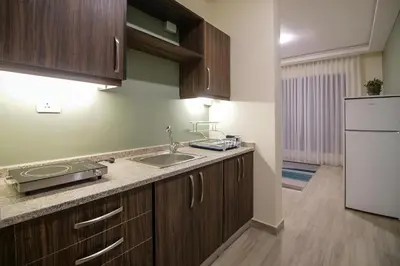 a kitchen with a sink and a refrigerator at 46 Serviced Apartments in Amman