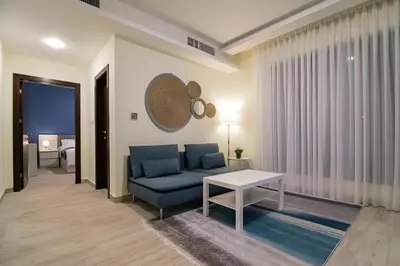 a living room with a blue couch and a table at 46 Serviced Apartments in Amman