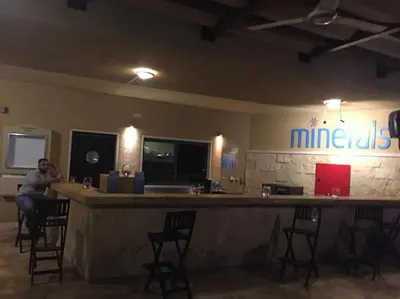 a man sitting at a bar in a restaurant at Dead Sea Jordan Sea View Samarah Resort Traveler Award 2024 winner in Sowayma