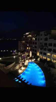 a view of a swimming pool at night at Dead Sea Jordan Sea View Samarah Resort Traveler Award 2024 winner in Sowayma