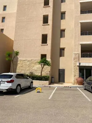 a car parked in a parking lot in front of a building at Dead Sea Jordan Sea View Samarah Resort Traveler Award 2024 winner in Sowayma