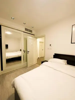 a hotel room with two beds and a mirror at central apartment for rent 31 in Umm Uthainah