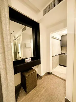 a bathroom with a large mirror and a stool at central apartment for rent 31 in Umm Uthainah