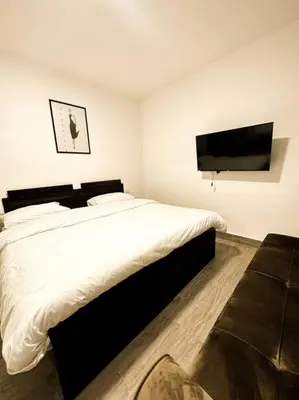 a bedroom with a large bed and a flat screen tv at central apartment for rent 31 in Umm Uthainah