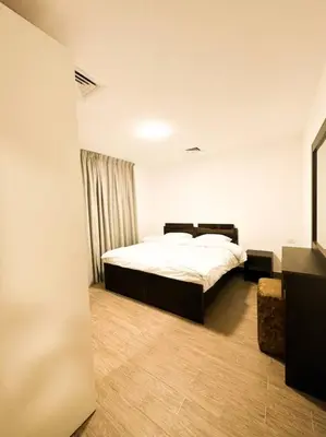 a bedroom with a bed and a large window at central apartment for rent 30 in Umm Uthainah