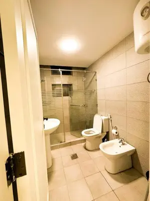a bathroom with a toilet and a sink at central apartment for rent 30 in Umm Uthainah