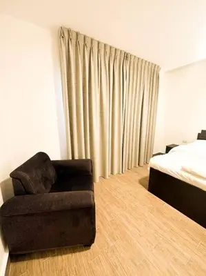 a living room with a chair and a bed at central apartment for rent 29 in Umm Uthainah