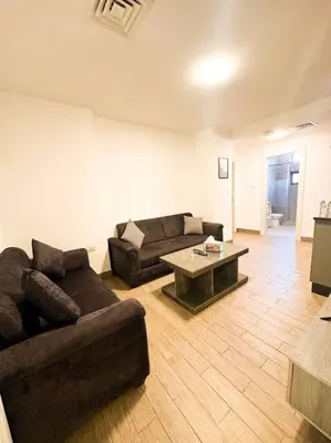 a living room with two couches and a coffee table at central apartment for rent 29 in Umm Uthainah