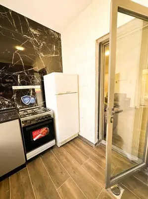 a kitchen with a stove and a refrigerator at central apartment for rent 28 in Umm Uthainah