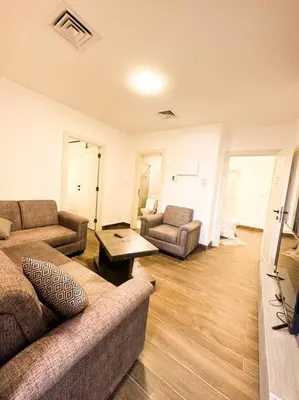 a living room with two couches and a table at central apartment for rent 28 in Umm Uthainah