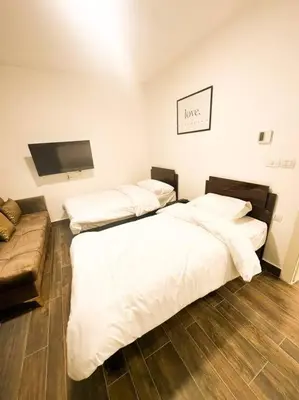 a bedroom with two beds and a flat screen tv at central apartment for rent 24 in Umm Uthainah
