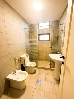 a bathroom with a toilet and a sink at central apartment for rent 25 in Umm Uthainah