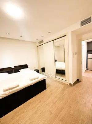 a bedroom with a large bed and a mirror at central apartment for rent 26 in Umm Uthainah
