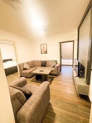 a living room with a couch and a table at central apartment for rent 27 in Umm Uthainah