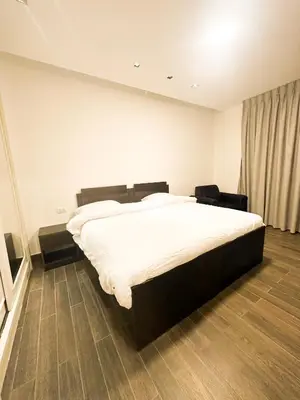 a bedroom with a large white bed and a window at central apartment for rent 27 in Umm Uthainah