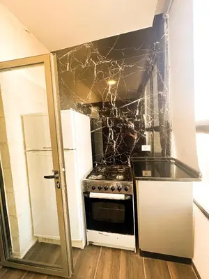 a kitchen with a stove and a refrigerator at central apartment for rent 27 in Umm Uthainah