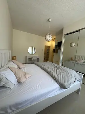 a bedroom with a large bed with white sheets and pillows at Modern chic haven in Amman