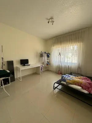 a bedroom with a bed and a desk and a window at Modern chic haven in Amman