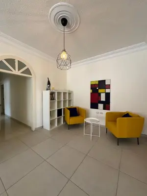 a living room with two yellow chairs and a table at Modern chic haven in Amman