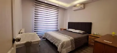 a bedroom with a bed and a window with blinds at MK3 - Two Bedroom Apartment in Amman