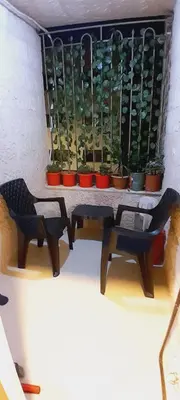 a table and two chairs in front of a window with plants at MK3 - Two Bedroom Apartment in Amman