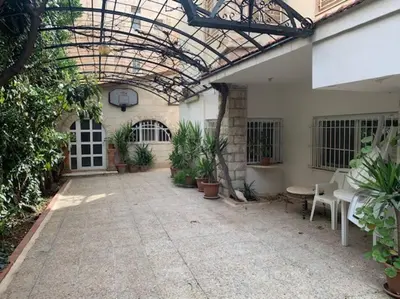 a patio with plants and a glass ceiling at Charming Apartment in Shmeisani in Amman