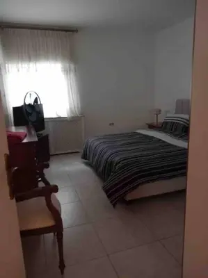a bedroom with a bed and a chair and a window at Charming Apartment in Shmeisani in Amman