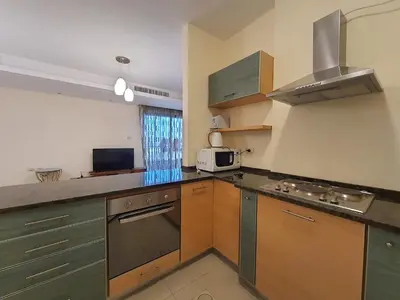a kitchen with wooden cabinets and a sink and a microwave at Abdoun Panorama in Amman