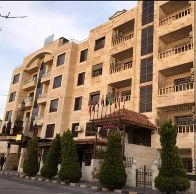 a large building with trees in front of it at Seven stars hotel apartment in Amman
