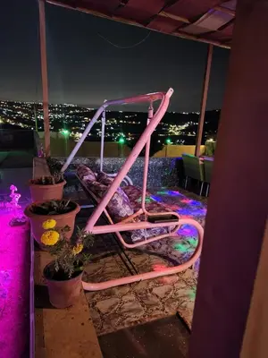 a pink object sitting on a balcony at night at shalyh tal birin in Şarrūt