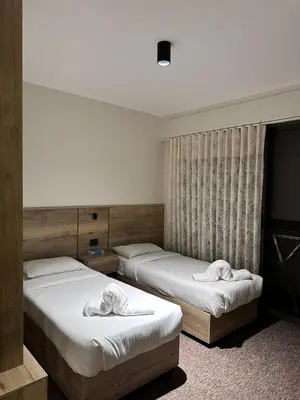 two beds in a hotel room with towels on them at Alraha VIP Marsa zayed Aqaba in Aqaba