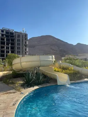 a water slide in a resort with a swimming pool at Alraha VIP Marsa zayed Aqaba in Aqaba