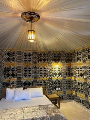 a bedroom with a bed and a chandelier at Rum Under The Stars Camp in Wadi Rum
